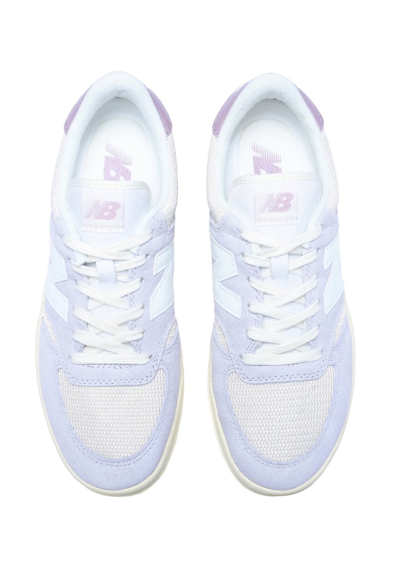 Zapatillas moradas y blancas que combinan materiales de ante y malla, diseño de cordones, cuello acolchado y un logotipo visible en la lengüeta.