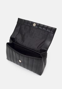 Czarna skórzana torebka z pikowanym wzorem. Otwiera się na gładkie wnętrze z powtarzającym się logo marki. Zapięcie na zatrzask.