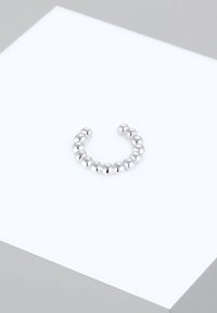 Anello a cerchio in argento composto da piccole perle sferiche lucidate disposte in forma circolare. Superficie metallica liscia con texture riflettente.