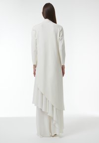 Lange witte cardigan met een gedrapeerde achterkant en een geribbelde textuur, met licht uitlopende mouwen en een soepele, vloeiende silhout.