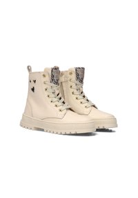 Crème-kleurige leren enkellaarsjes met een textuur, beige veters, zigzag profielzolen, hartvormige uitsparingen en tonglabels met zebra-prints.