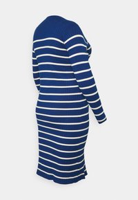 Vestido em malha canelada na cor azul escuro com riscas horizontais brancas, mangas longas e uma ligeira evasé na bainha. Vista traseira exibida.