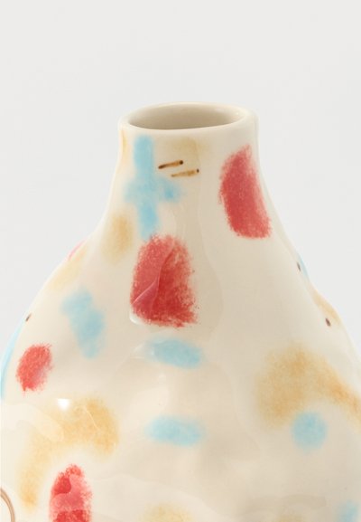 Γυαλιστερό κρεμ κεραμικό βάζο με ακανόνιστα κόκκινα, μπλε και μπεζ στίγματα στο στρογγυλό σώμα του και στενό άνοιγμα.