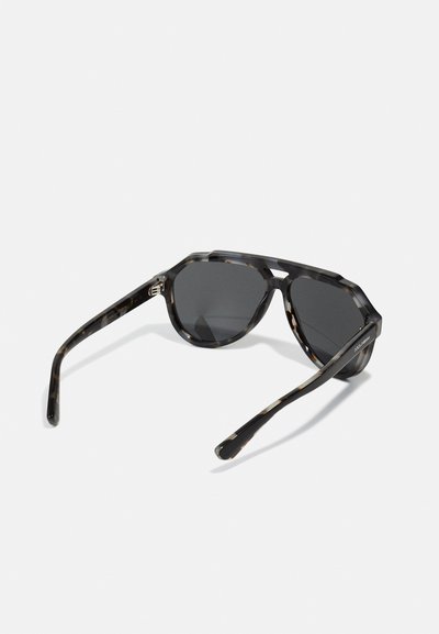 Ochelari de soare cu rame octogonale din tortoise shell și lentile întunecate. Prezintă brațe groase, cu un model, pentru un plus de stil și aderență.