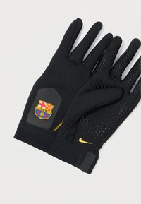 Fekete kesztyűk, textúrált fogással, Barcelona-logóval a csuklón és sárga Nike pipa emblémával. Rugalmas, hőszigetelő anyagból készültek.