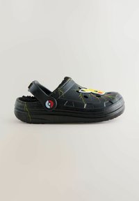 Zwarte rubberen klomp met Pikachu-ontwerp, voorzien van bliksemgraphics en een rood-wit logo-knop. Gecoate zool voor grip.