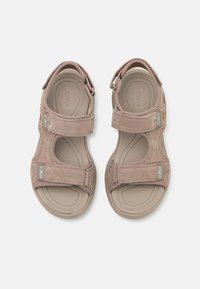 Brune semskede sandaler med justerbare Velcro-remmer, teksturerte innersåler og gummisåler. Har en liten turkis logo på remmen.