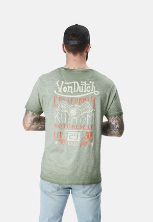 T-shirt vert à manches courtes avec un motif vintage au dos représentant "Von Dutch", des ailes et des graphiques de moto. Texture douce, design décontracté.