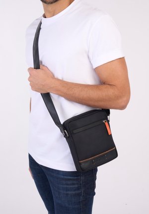 HOME RUN - Cross body bag - black/orange