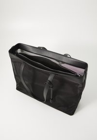 Black nylon tote bag with a smooth texture, featuring dual top handles and a zippered opening. Inside has a contrasting light purple lining.