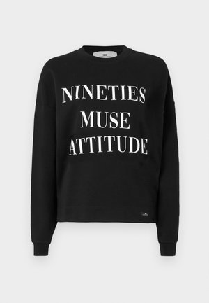 Svart hettegenser med lange ermer, rund hals, og hvit tekst som står "NINETIES MUSE ATTITUDE." Myk stoff og avslappet passform.