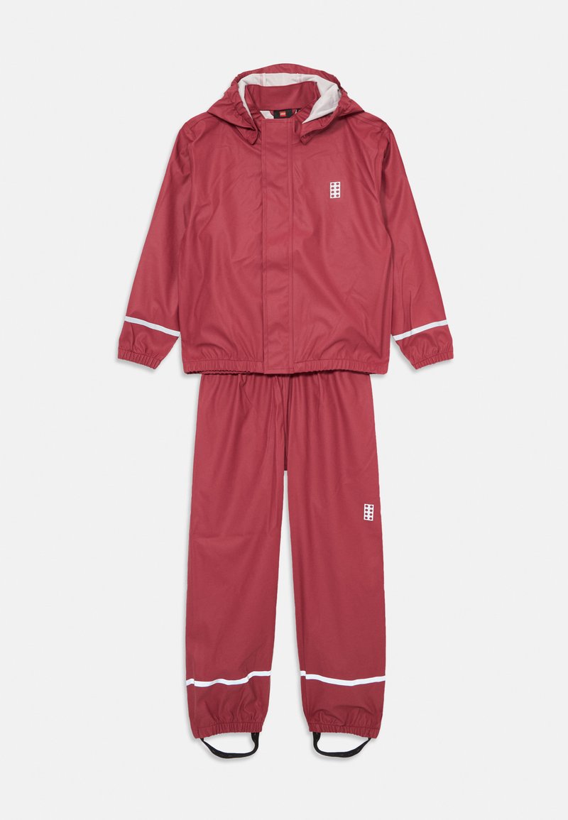 Fato de chuva impermeável vermelho com capuz. Apresenta punhos elásticos e bainha das calças, riscas refletoras brancas e um pequeno logótipo no peito e na perna.