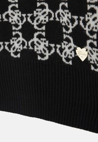 Schwarzer Strickpullover mit einem weißen Mustermuster, geripptem Saum und einem kleinen metallischen herzförmigen Logo.