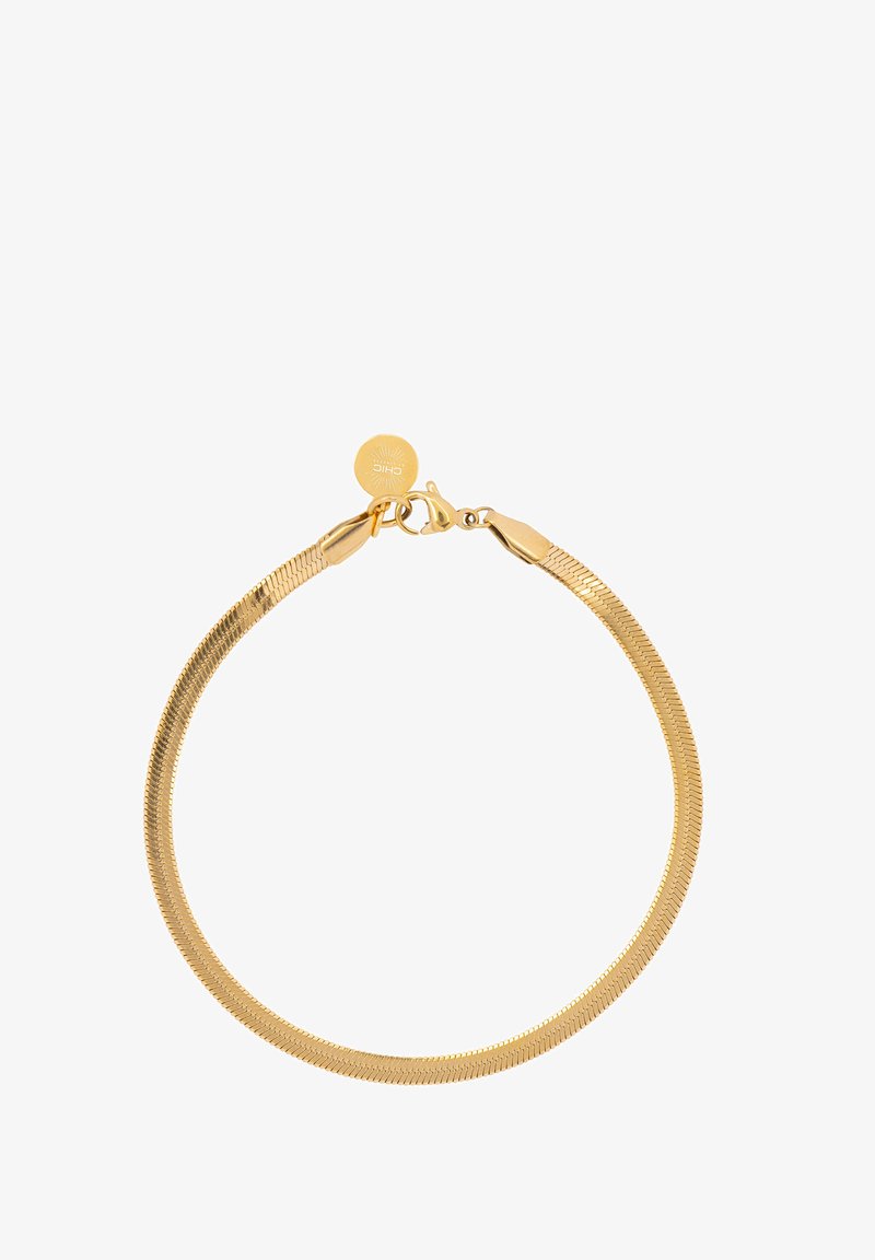 Pulsera de tono dorado con un diseño liso y flexible, que presenta un broche de langosta y una pequeña etiqueta redonda con un patrón de rayos de sol.