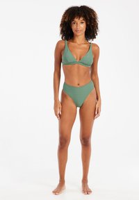 Zelený bikiny set obsahujúci trojuholníkový bralet so tenkými ramienkami a nohavičkami s vysokým pásom. Materiál má jemnú textúru a vzor.