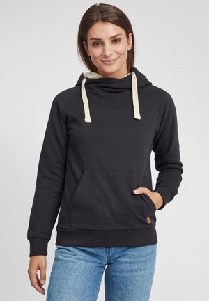 Sweatshirt noir avec capuche, cordons en crème, poche avant et poignets côtelés. Texture lisse avec une coupe décontractée et un petit détail de logo.