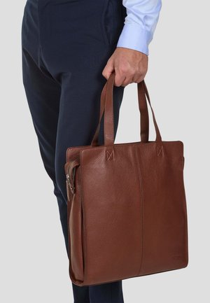 Brun läder tote-väska med texturerad yta, utrustad med två korta handtag, dragkedjestängning och vertikala sömnadsdetaljer.