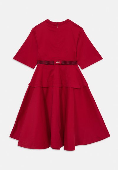 Vestido midi vermelho com mangas curtas, saia rodada e um cinto padrões preto e vermelho na cintura, visto de costas.
