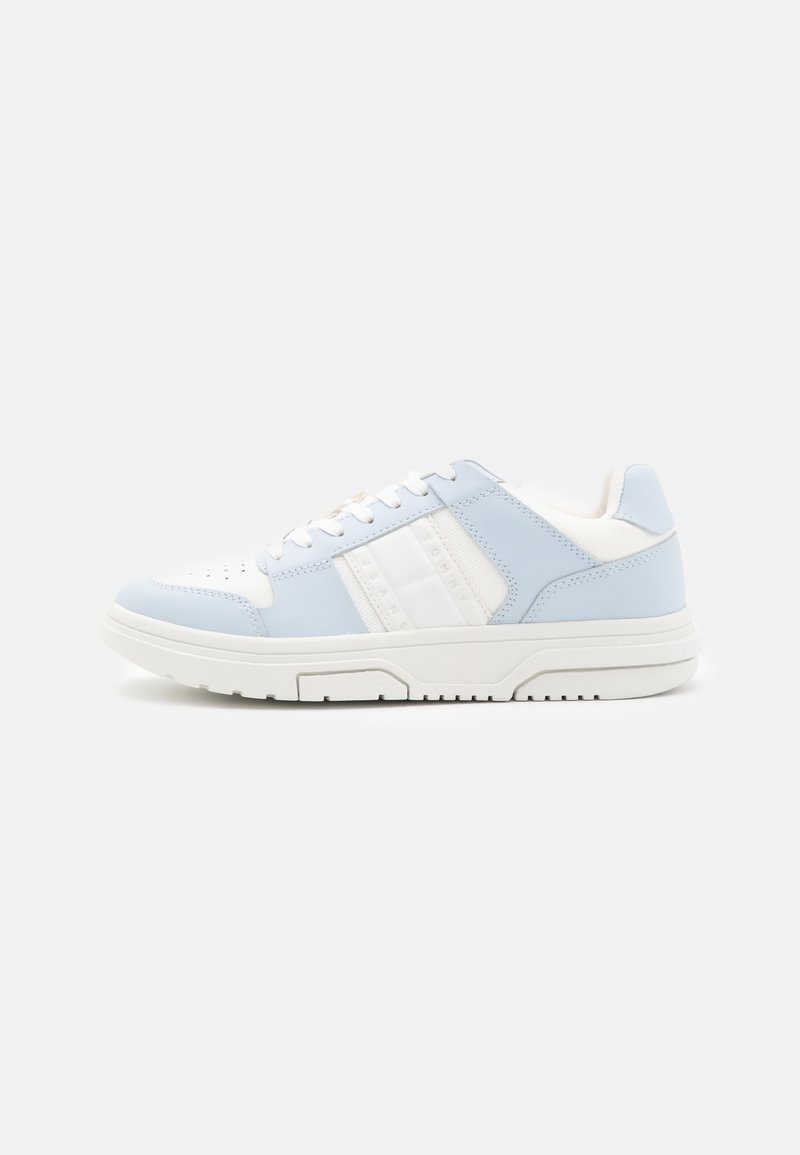 Light blue and white sneaker with a smooth leather upper, perforated toe, and textured side accents. Thick white rubber sole.