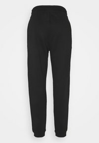Zwarte sweatpants van zacht stof; hebben een elastische tailleband en taps toelopende pijpen met strakke boorden bij de enkels. Naadloos ontwerp aan de achterkant.