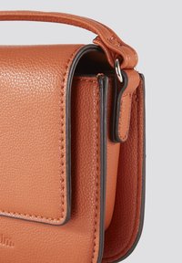 Læder crossover taske i varm orange, med struktureret overflade, kontrasterende mørk trim og et kort håndtag for alsidige bære muligheder.