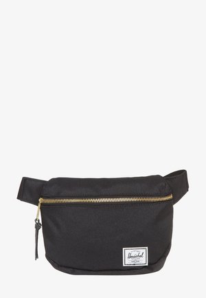 Zwarte Herschel heuptas met gouden ritssluiting en verstelbare band, rechthoekige logovlek in de rechterbenedenhoek.