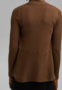 Bruine geribde cardigan met lange mouwen, een uitlopende zoom en een gestructureerde afwerking, met afwisselende horizontale en verticale ribbelpatronen.