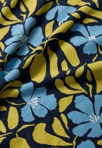 Material textil de culoare bleumarin cu un model floral, având flori mari albastre și frunze verzi. Materialul pare moale, cu o suprafață texturată.