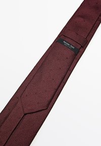 Burgunderfarvet slips med en struktureret vævning, der har en spids ende og en lille sort etiket, som står "Massimo Dutti, Made in Italy."