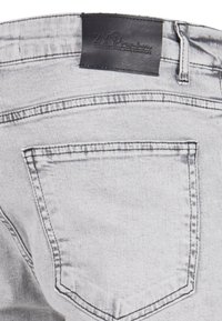 Hallid hallid teksad, millel on mustast nahast vöökoha silt ja tagataskul on õmblemisega ääristatud detailid. Sile tekstuur ja juhuslik disain.