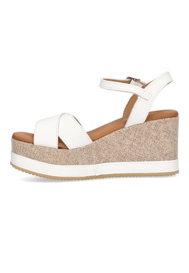 Sandalias de cuña de cuero sintético blanco con plataforma texturizada de lino y correa para el tobillo. Cuenta con una suela de goma y diseño de banda cruzada.