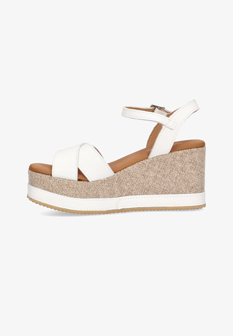 Sandalias de cuña de cuero sintético blanco con plataforma texturizada de lino y correa para el tobillo. Cuenta con una suela de goma y diseño de banda cruzada.