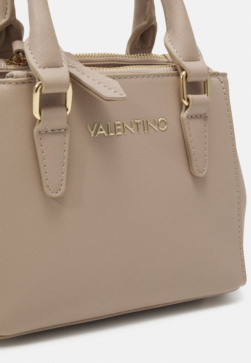 Sac à main beige Valentino en matériau texturé ; doté de quincaillerie dorée, de doubles poignées supérieures et d'un logo sur le devant.