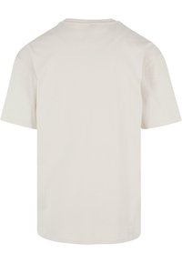 Kortermet T-skjorte med rund hals i lysebeige bomull, med en glatt tekstur og et enkelt design uten mønstre eller detaljer.