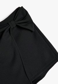 Zwarte shorts van gladde stof, met een opvallende knoopdetail bij de tailleband en scherpe randen.
