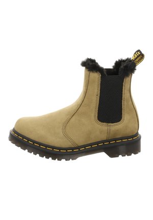 Ziegenwildleder-Stiefelette in Braun mit schwarzem elastischem Seitenteil, gelber Naht an der Sohle, schwarzem Fellfutter und gebrandetem Zuglasche auf der Rückseite.