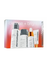 Il set di prodotti per la cura della pelle Dermalogica in una scatola include quattro prodotti: un gel detergente bianco, un microesfoliante argento, un siero dorato e un siero per gli occhi bianco.