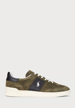 Olivgröna mocka sneakers med en marinblå accentpanel, vita snören och en logotyp. Har en texturerad yta och en vit gummisula.