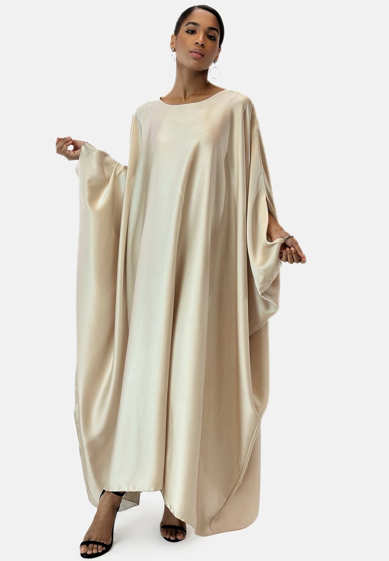 Beige satin klänning med lös passform, vida ärmar och rund halsringning, med en slät textur och flytande silhuett.