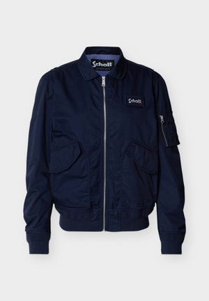 Veste zippée bleu marine avec poches à rabat, poignets et ourlet côtelés, petite poche zippée sur la manche, et patch logo Schott sur la poitrine.