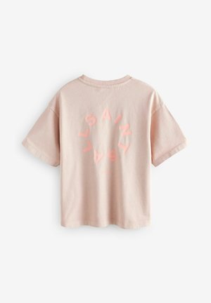 T-shirt en coton rose clair à manches courtes et col rond. Présente un design de texte circulaire au dos dans une teinte rose plus foncée.
