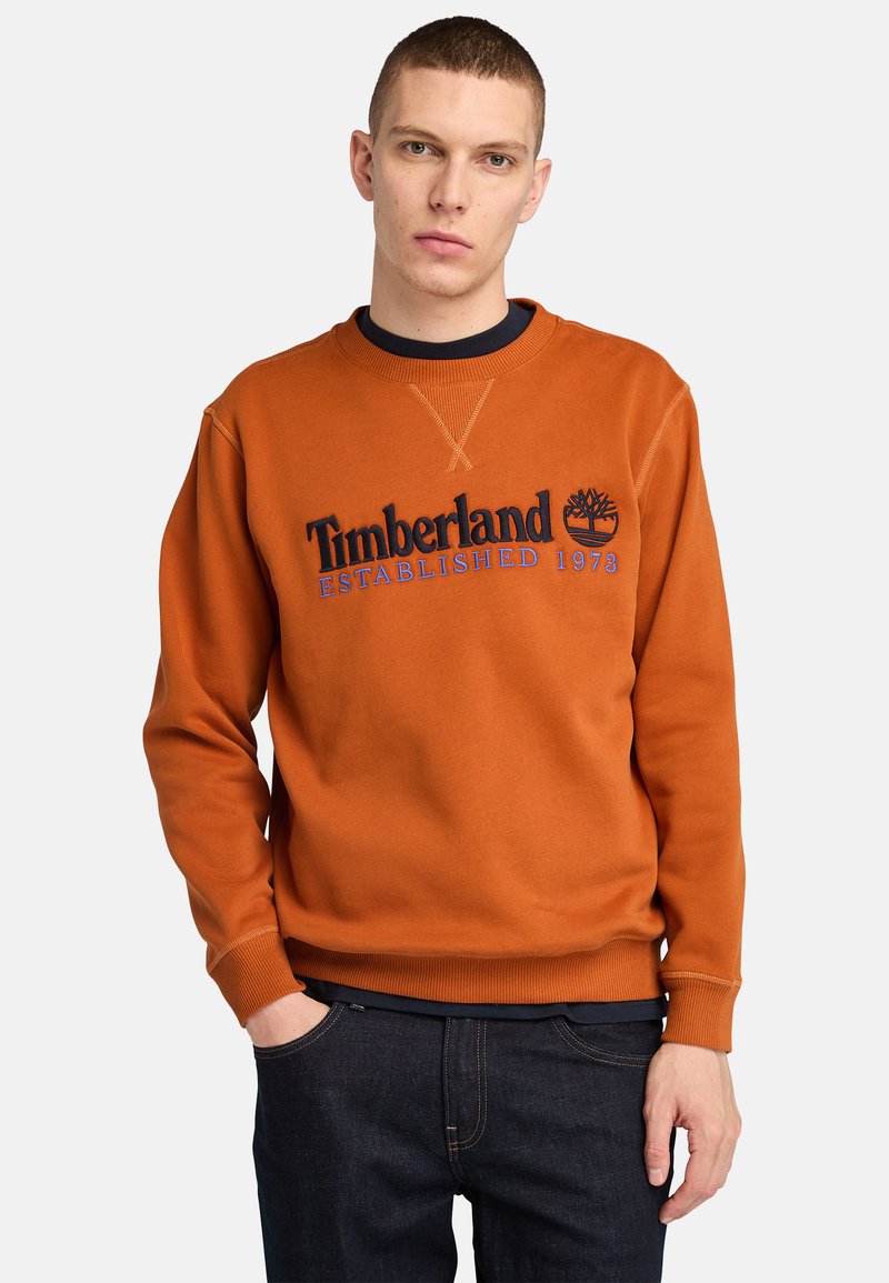 Felpa a girocollo arancione in cotone, con logo "Timberland" ricamato in blu e data di fondazione, con polsini e orlo a coste.