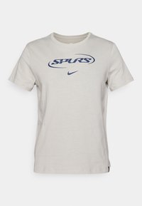 Heledhall halles hallides t-särk, millel on tume sinine "SPURS" logo ja väike Nike swoosh. Tavaline ümar kaelus ja lühikesed varrukad.