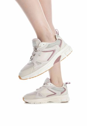 Zapatillas deportivas beige con materiales de malla y ante, acentos rosas, una suela blanca gruesa y un cuello acolchado. Presentan un cierre de cordones y un detalle de logotipo.