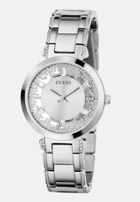 Hõbedane roostevabast terasest käekell ümmarguse näoga. Omab kristallaktsente, valget kellapinda ja lingitud rihma, millel on ristkülikukujulised lingid.