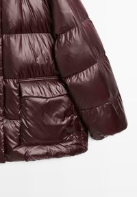 Maroon puffer jacket sleeve and lower front with large flap pocket, quilted insulated design, and smooth shiny fabric.