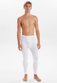 White thermal leggings with a fitted design and elastic waistband. Made from soft, stretchable material, featuring a front pouch and ribbed cuffs.