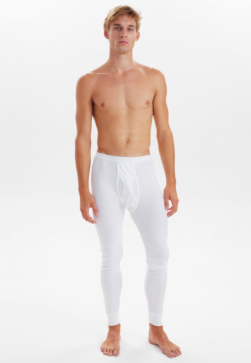 White thermal leggings with a fitted design and elastic waistband. Made from soft, stretchable material, featuring a front pouch and ribbed cuffs.