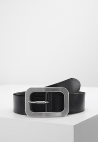 Ceinture en cuir noir avec une large boucle rectangulaire en argent ; texture lisse, design plat et quincaillerie minimaliste.