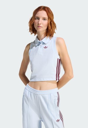 Lyseblå kort polo med krave, der har en karmosinrød logo og lodrette karmosinrøde striber på siderne. Glat stoftekstur.